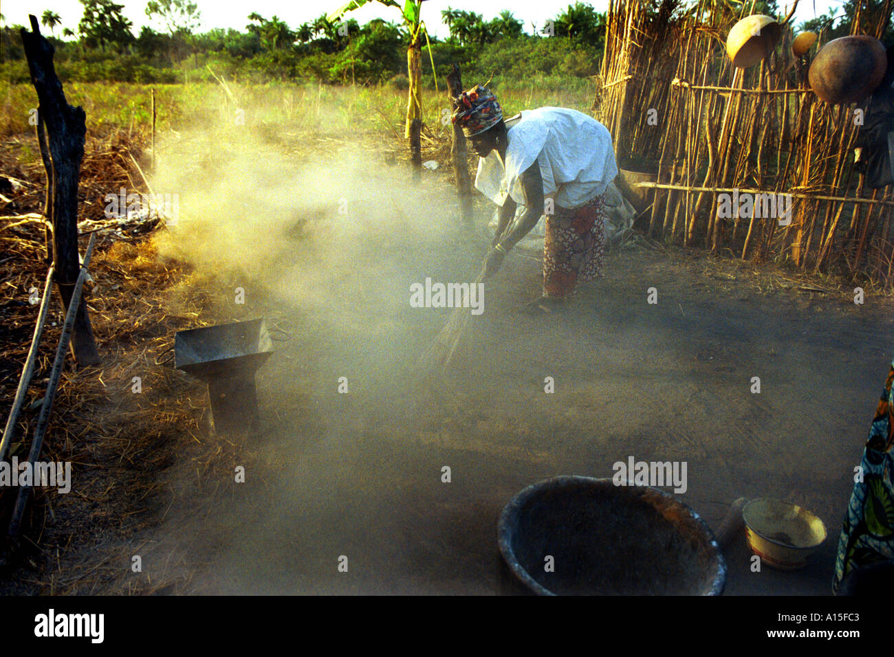 Lama Uma spazza il suo cortile dove si cuoce la cena nel villaggio di Dembel Jumpora nel paese africano e Dell'ovest della Guinea Bissau. Foto Stock