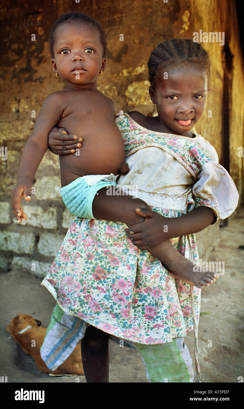 I bambini sono già in cura per bambini mentre le loro mamme lavorano in campi di riso nel Fulani villaggio di Dembel Foto Stock