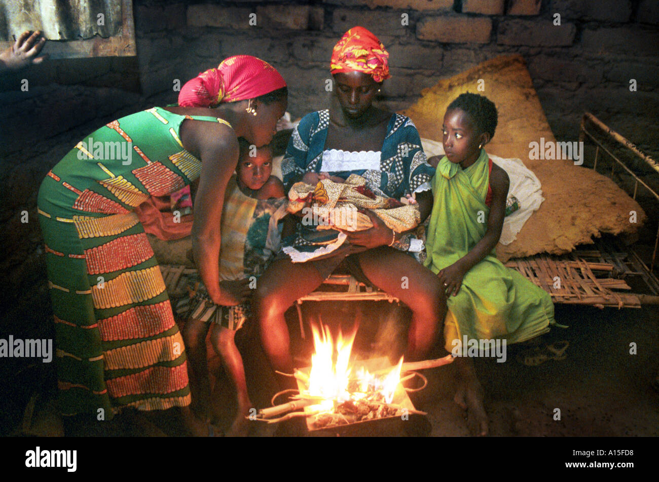 I membri della famiglia di sedersi con una madre e il suo neonato in Fulani vialage di Dembel Jumpora situato nel West African Foto Stock
