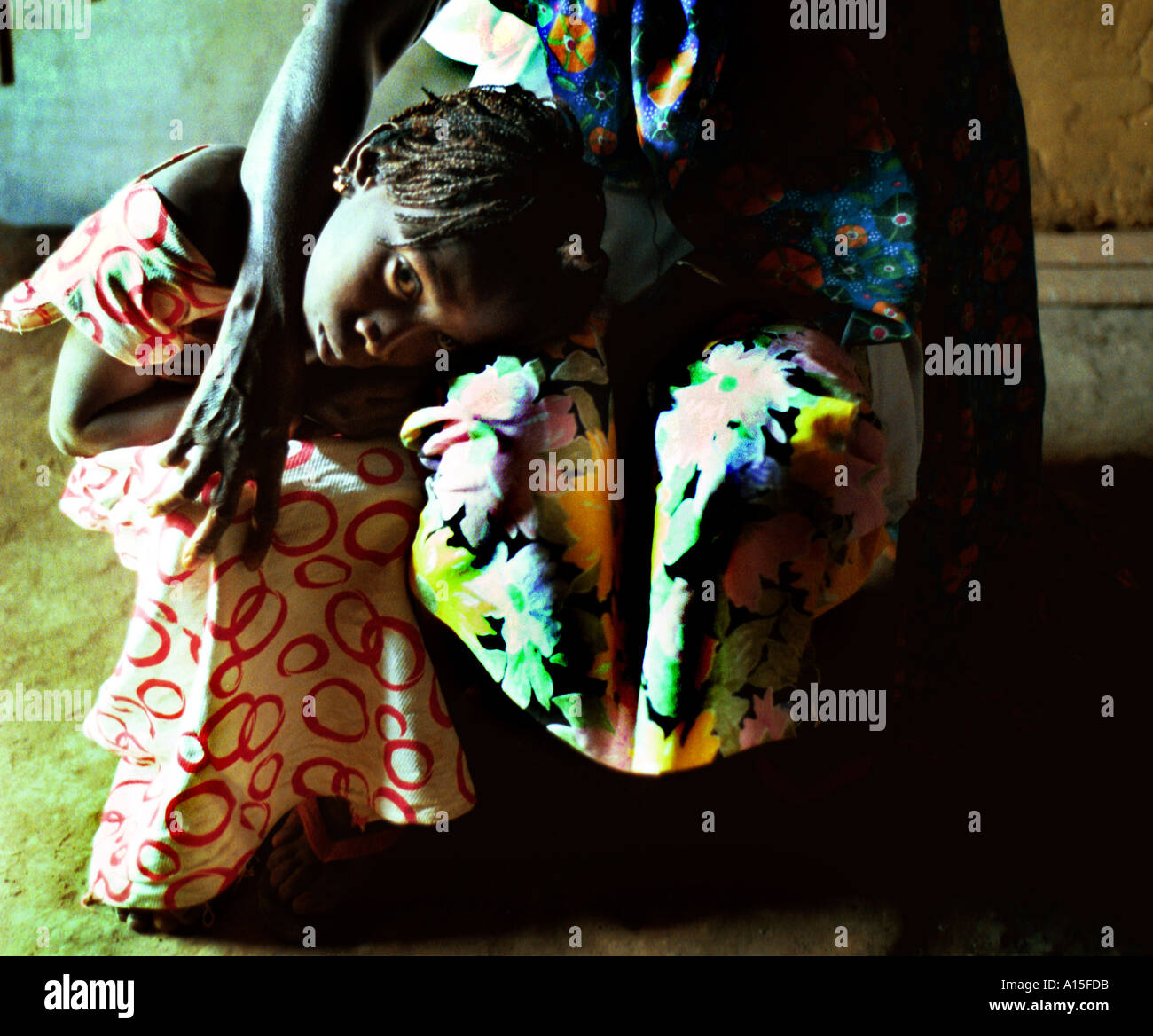 Un bambino si appoggia nel suo giro delle madri in Fulani villaggio di Dembel Jumpora situato nel paese africano e Dell'ovest della Guinea Bissau. Foto Stock