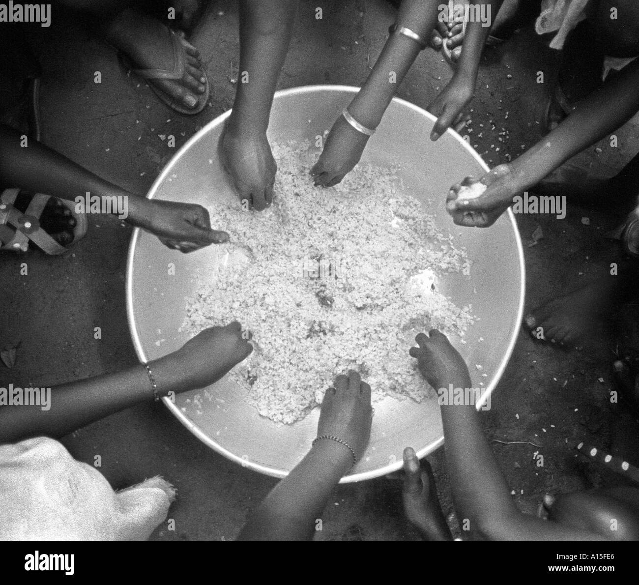 I bambini mangiano la pinzatura del raccolto di riso proveniente da un recipiente grande nel villaggio di Dembel Jumpora in teh paese della Guinea Bissau. La Guinea Foto Stock