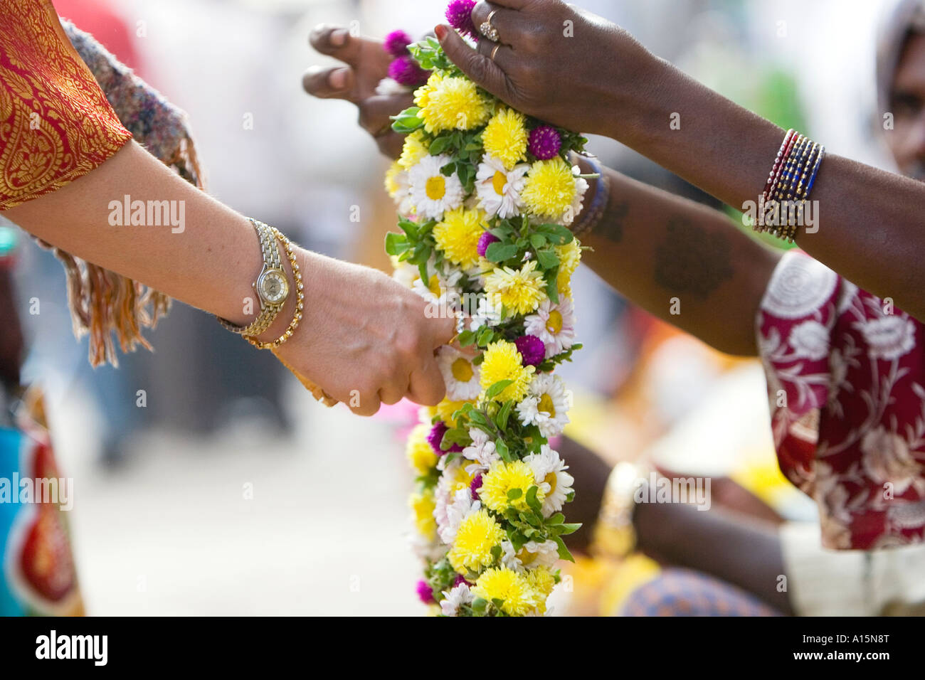 Western devoto acquisto ghirlanda di fiori da indiano street commerciante a Puttaparthi , India meridionale. messa a fuoco selettiva Foto Stock