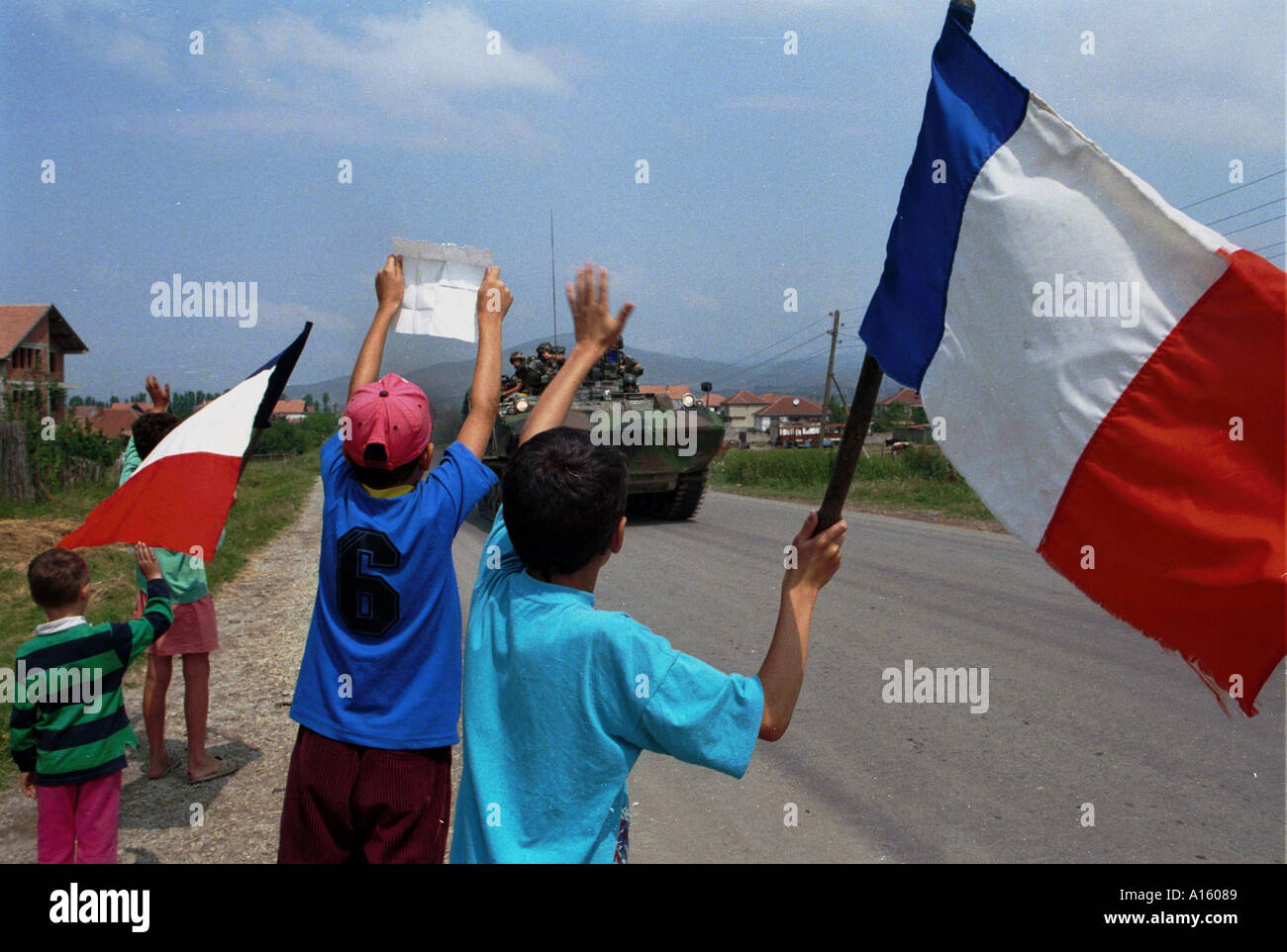 Le persone di etnia albanese onda bandiere francesi come unità della NATO da vicino a Mitrovice venerdì 2 luglio 1999 in Kosovo Foto di Ami Vitale Foto Stock