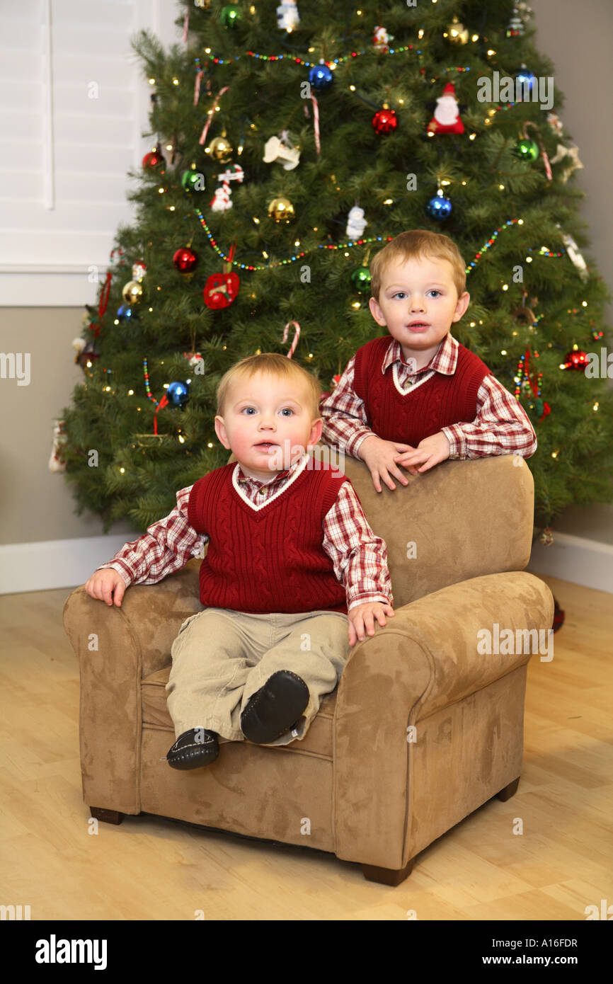 Due giovani ragazzi nella parte anteriore dell albero di Natale Foto Stock