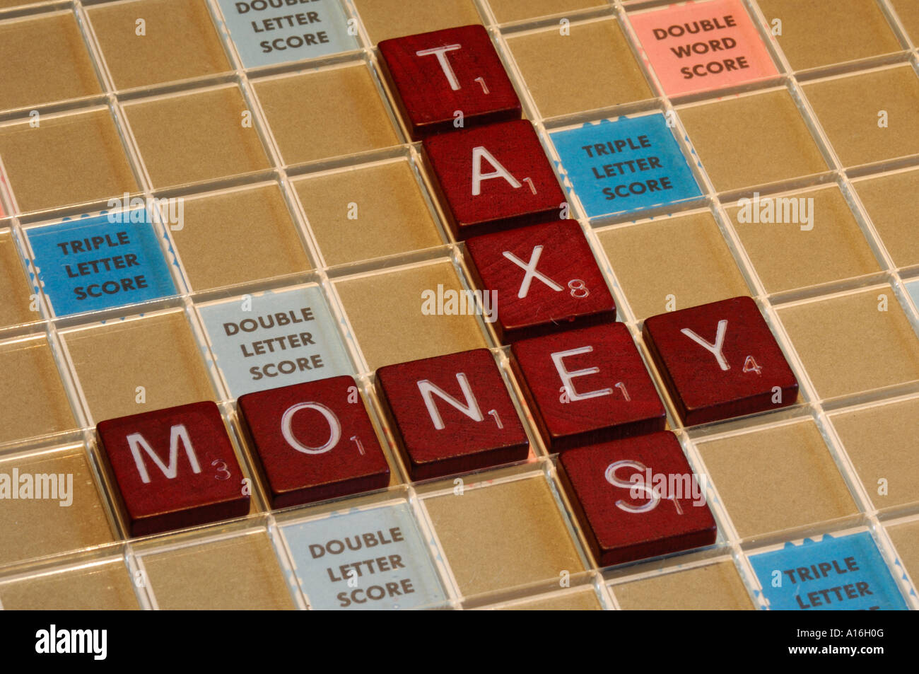 Piastrelle Scrabble l'ortografia delle parole il denaro e le tasse Foto Stock