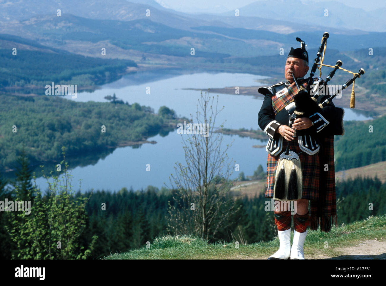 Suonatore di cornamusa scozzese con cornamusa vicino al Loch bagpiper Foto Stock