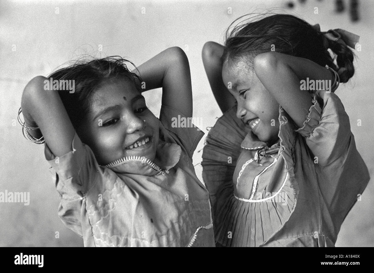 B / W di due ragazze ridenti che ballano in un centro di giorno che si prende cura dei bambini di prostitute.Calcutta, India Foto Stock