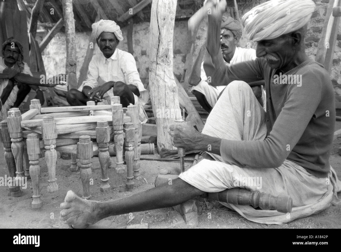 B/N di un carpentiere anziano che fa mobili, seduto a terra. Kishangargh, Rajasthan, India. Foto Stock