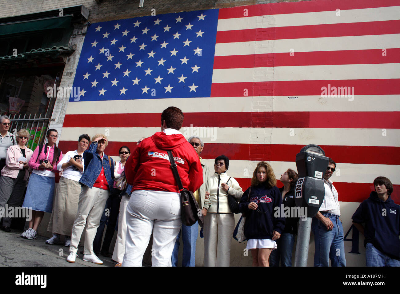 Un Enthnically diversificato gruppo Tour di fronte a un enorme bandiera americana, San Francisco, California Foto Stock
