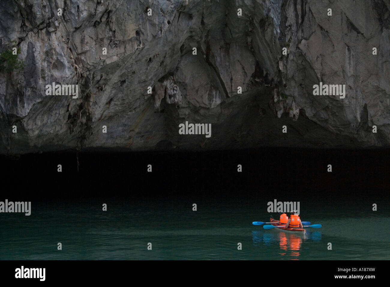 2007 turiste kayak guidato in un Deap oscura grotta Tunnel Halong Bay Vietnam Foto Stock
