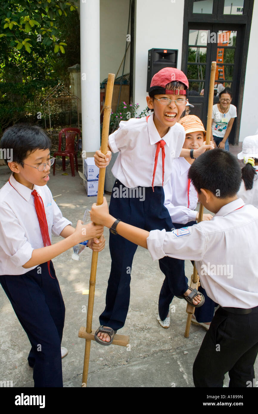Scuola 2007 ragazzi provare a camminare su bastoni o palafitte Vietnam Museo di Etnologia Hanoi Foto Stock