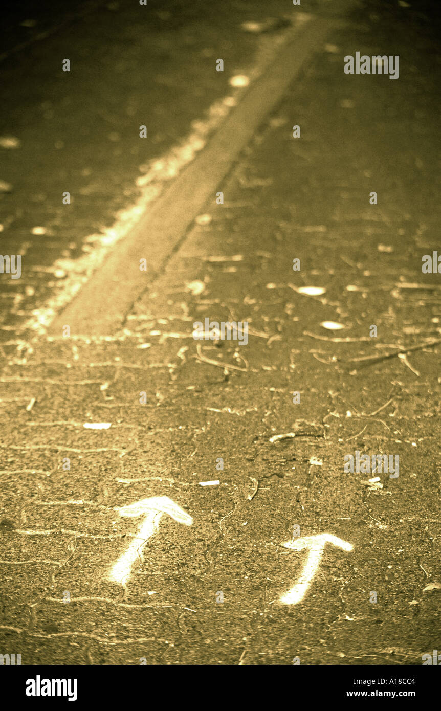 Due frecce dipinte sul marciapiede Foto Stock