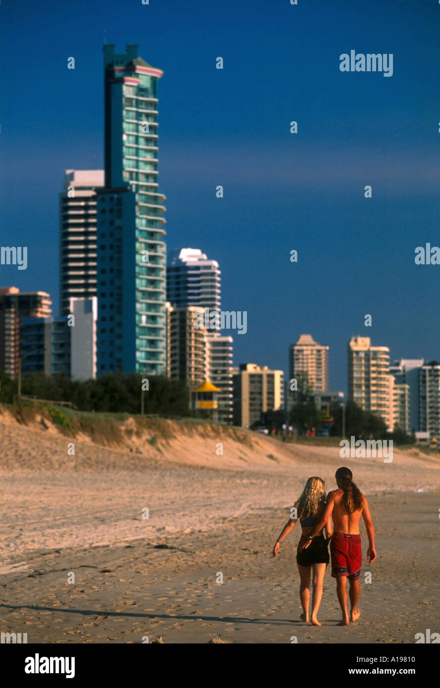 Giovane camminando sotto braccio giù alla spiaggia di Surfer s Paradise Queensland Australia R Francesco Foto Stock