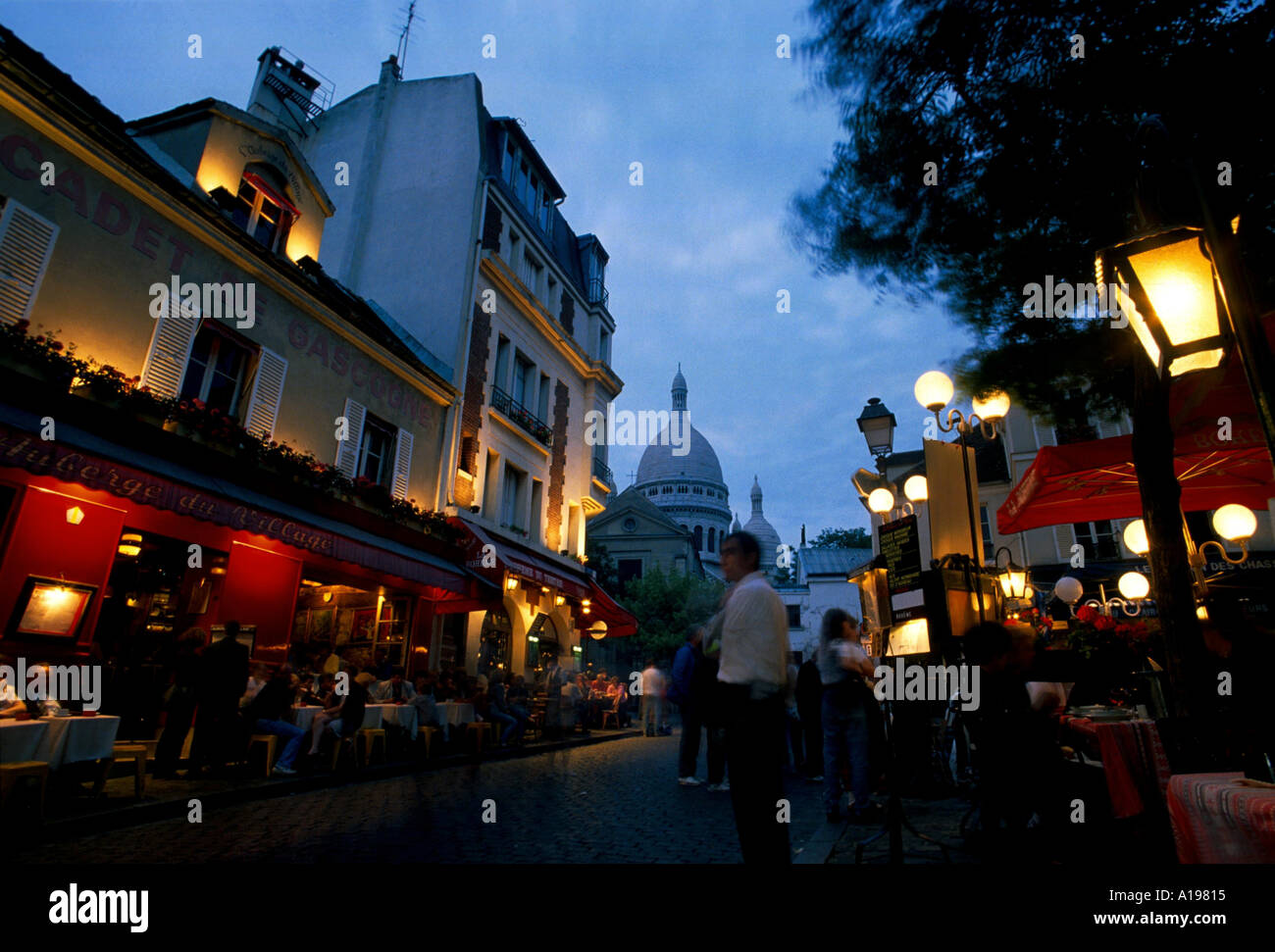 La Place du Tertre popolare con i turisti per i ristoranti e gli artisti della pavimentazione con la cupola del Sacre Coeur dietro Foto Stock