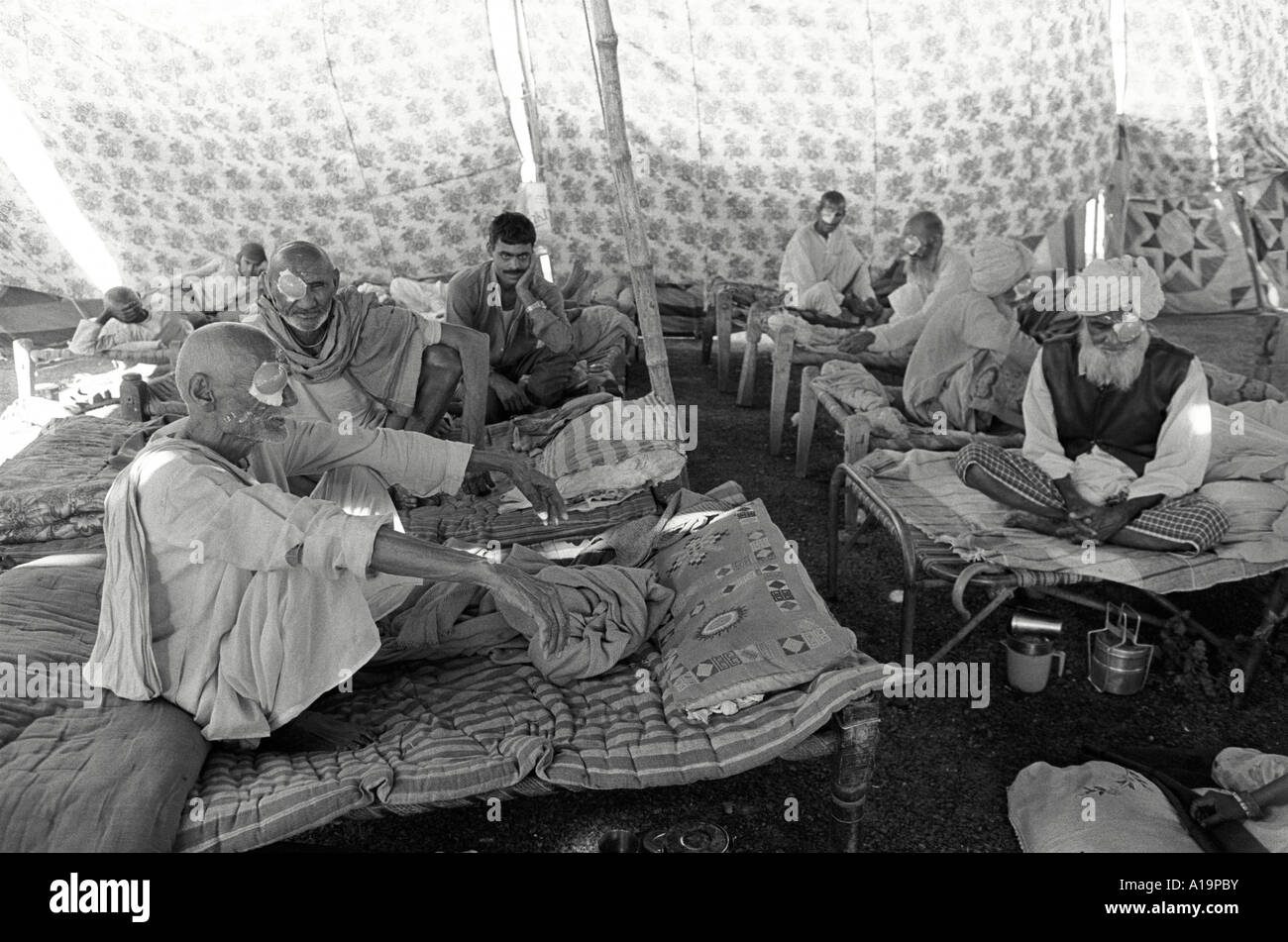 B/N di pazienti anziani in ripresa da operazioni di cataratta in un campo di trattamento degli occhi in Rajasthan rurale, India Foto Stock