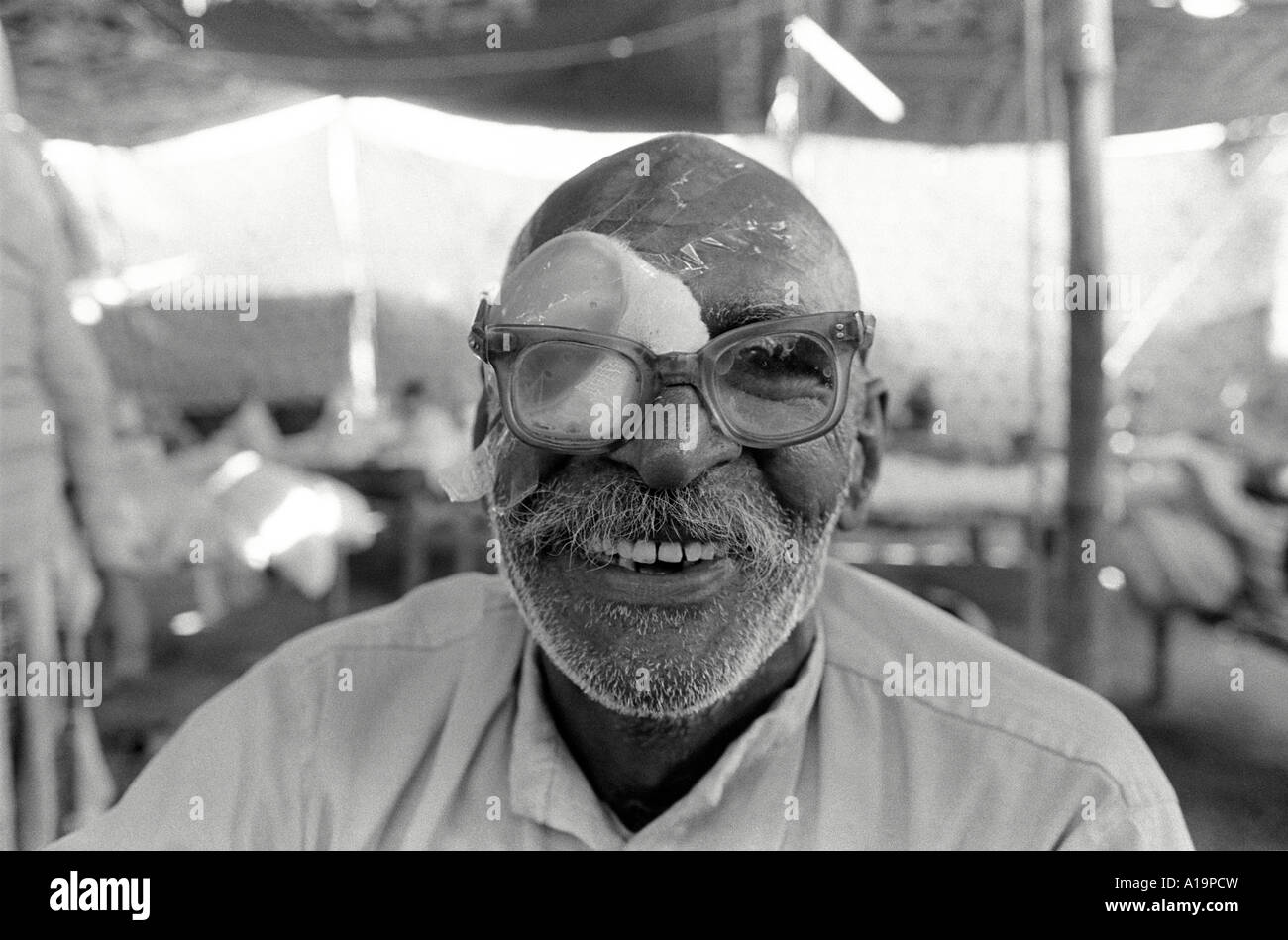 Uomo anziano che si sta riprendendo dalla chirurgia della cataratta in una clinica temporanea di viaggio degli occhi nella Rajasthan rurale, India Foto Stock