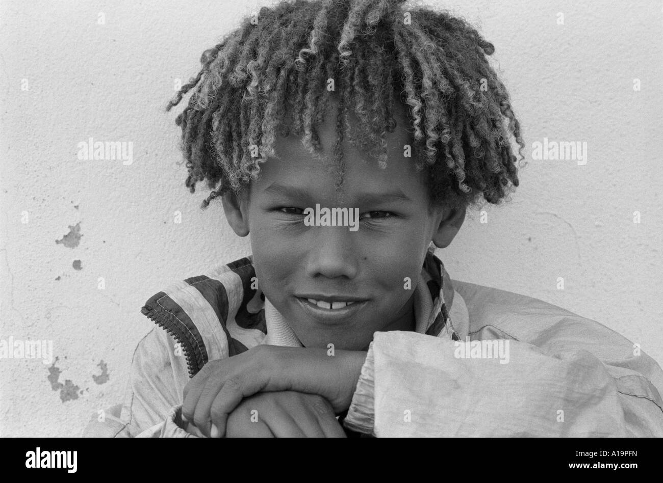 Ritratto B/N di un sorridente ragazzo misto di razza Swazi/patrimonio europeo con mini dreadlock . Eswatini (Swaziland) Foto Stock