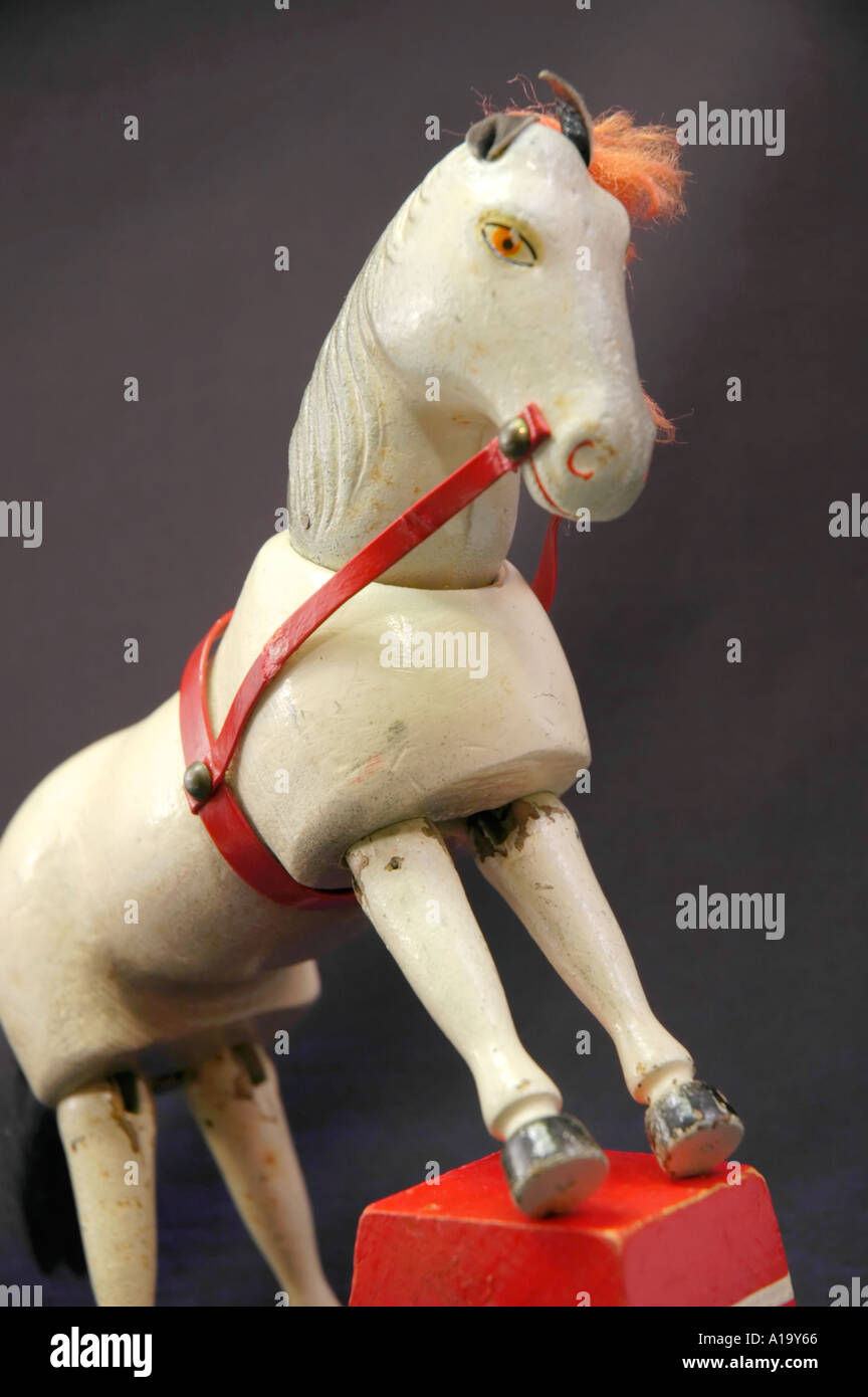 In legno antico giocattolo di circo cavallo bianco in piedi con la sua parte anteriore unghioni su uno sgabello Foto Stock