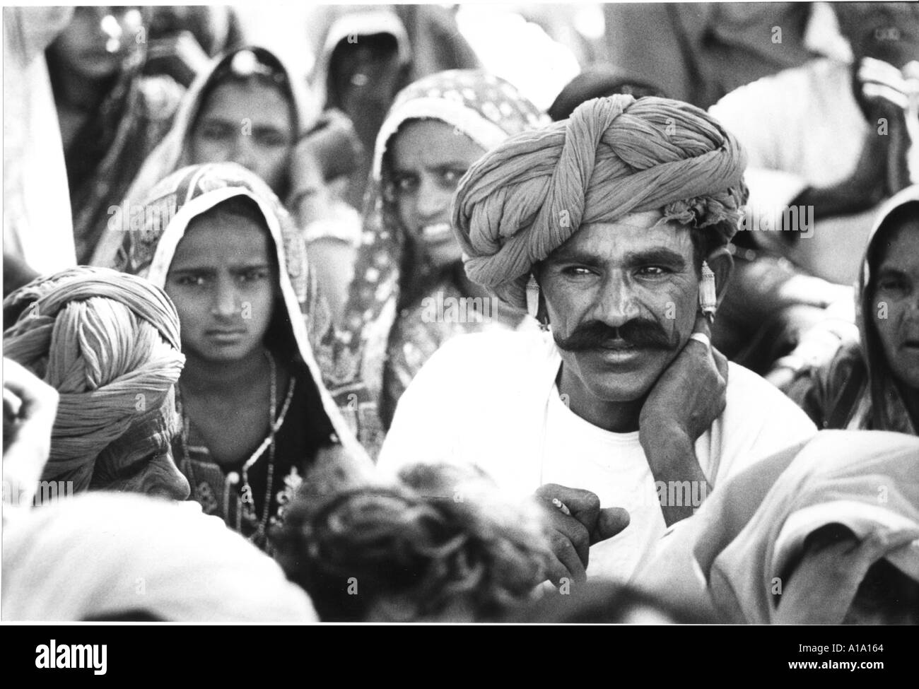 Un uomo indiano con un enorme turbante e grandi baffi con il capo coperto moglie in Pushkar fair in India Foto Stock