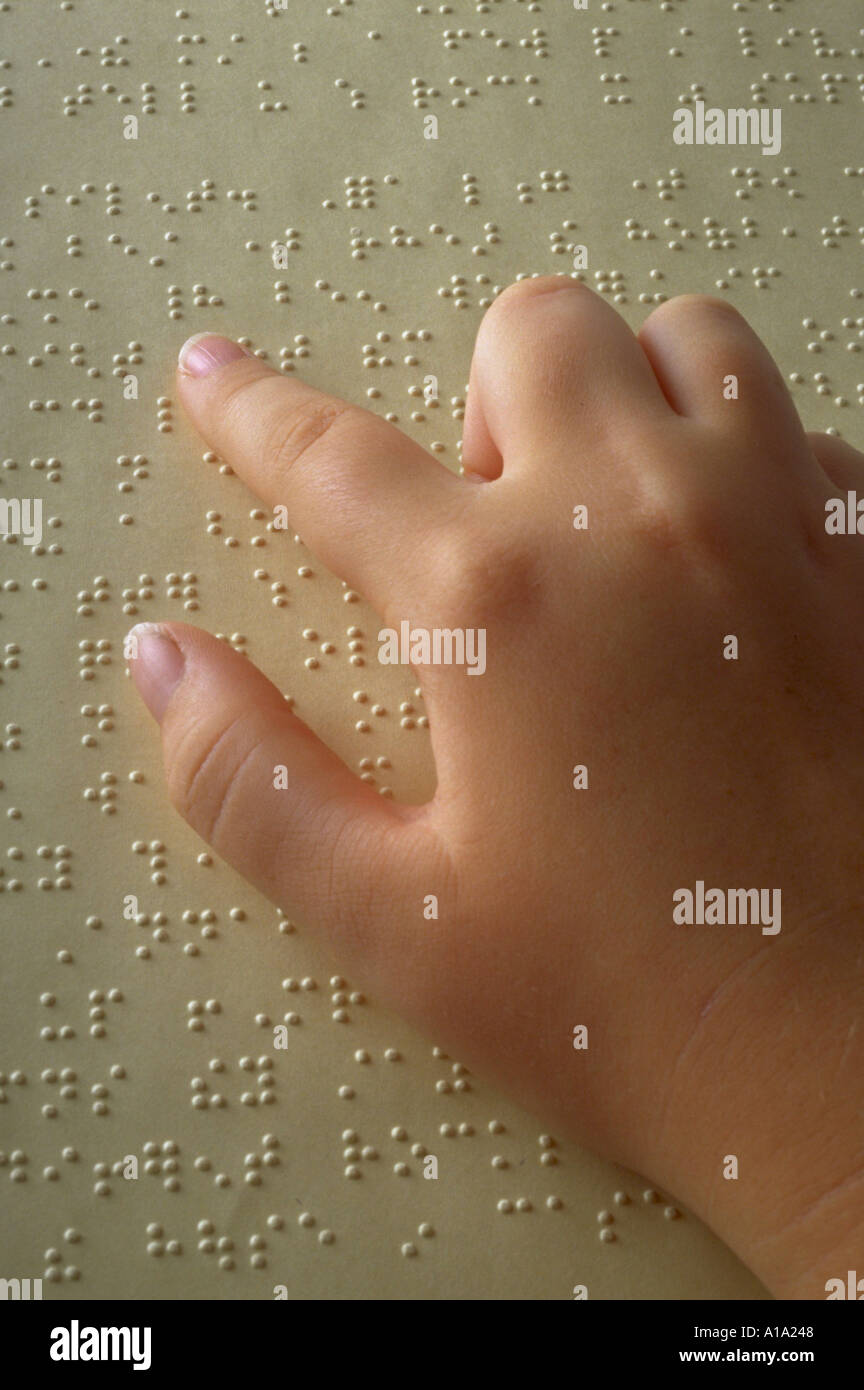 Close up di un bambino la mano la lettura di un libro di braille Foto Stock