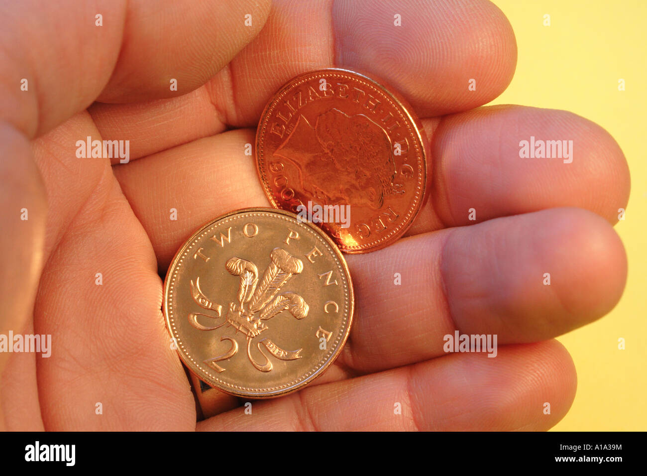 British 2p due penny monete in mano un piccolo cambiamento cambiamento allentato coppers contanti Foto Stock