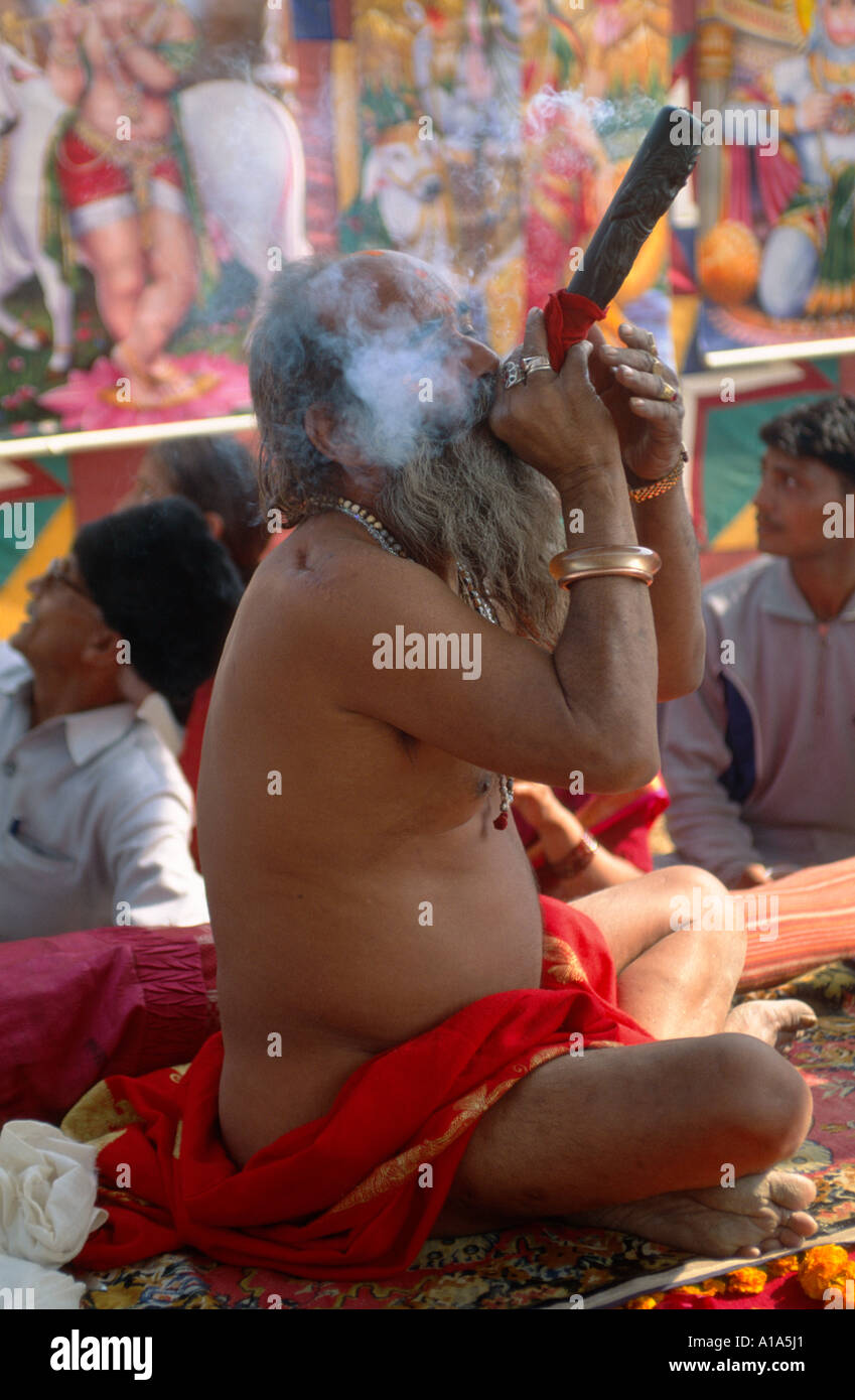 Baba Mast giri, un naga sadhu dall'Juna Akhara fumare una chillum di charras, Maha Kumbh Mela, Allahabad, Uttar Pradesh, India Foto Stock