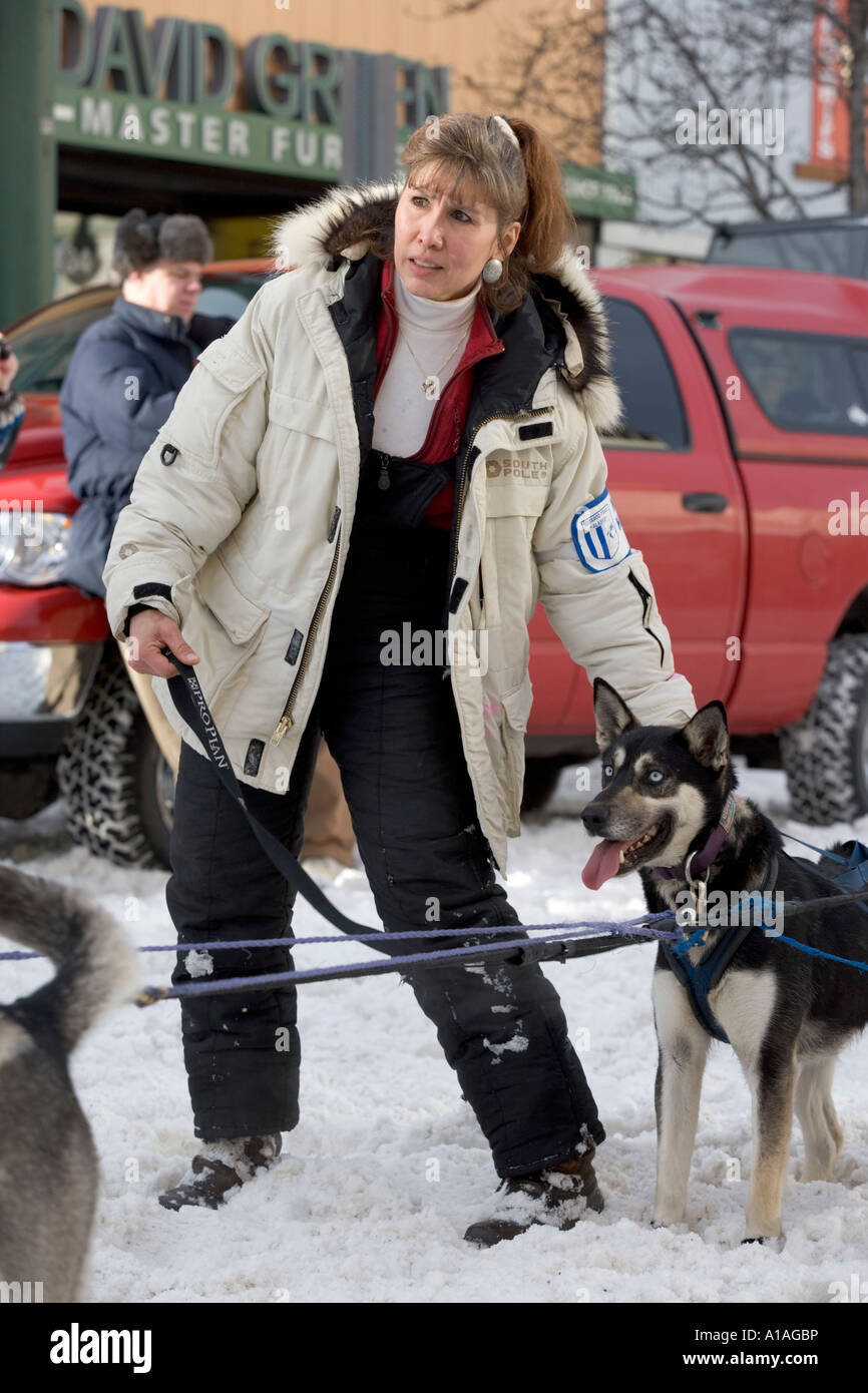 Stati Uniti d'America Alaska gestore di ancoraggio detiene i team di cane conduce nella neve lungo la quarta Avenue Foto Stock