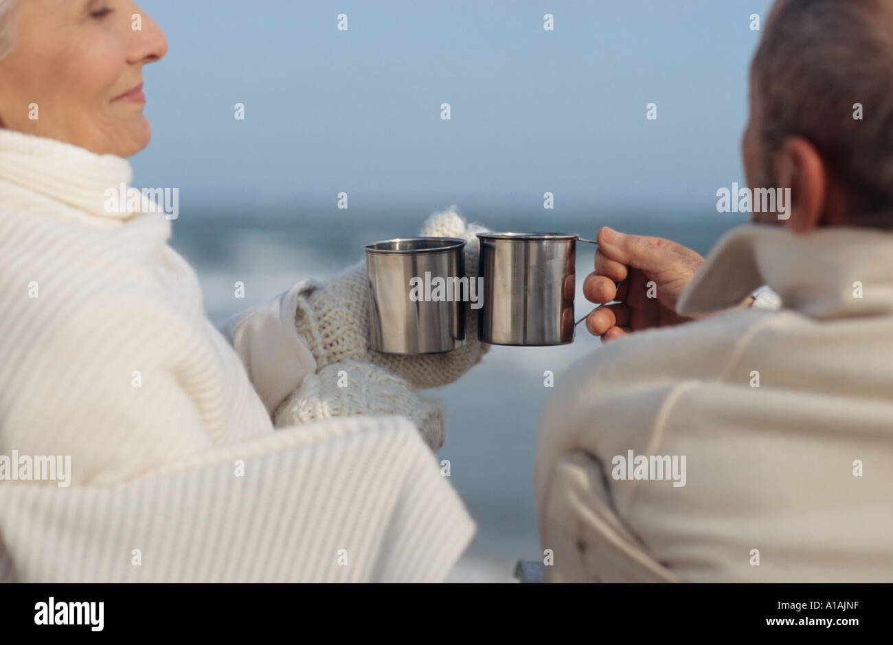 Coppia senior avente un drink sulla spiaggia Foto Stock