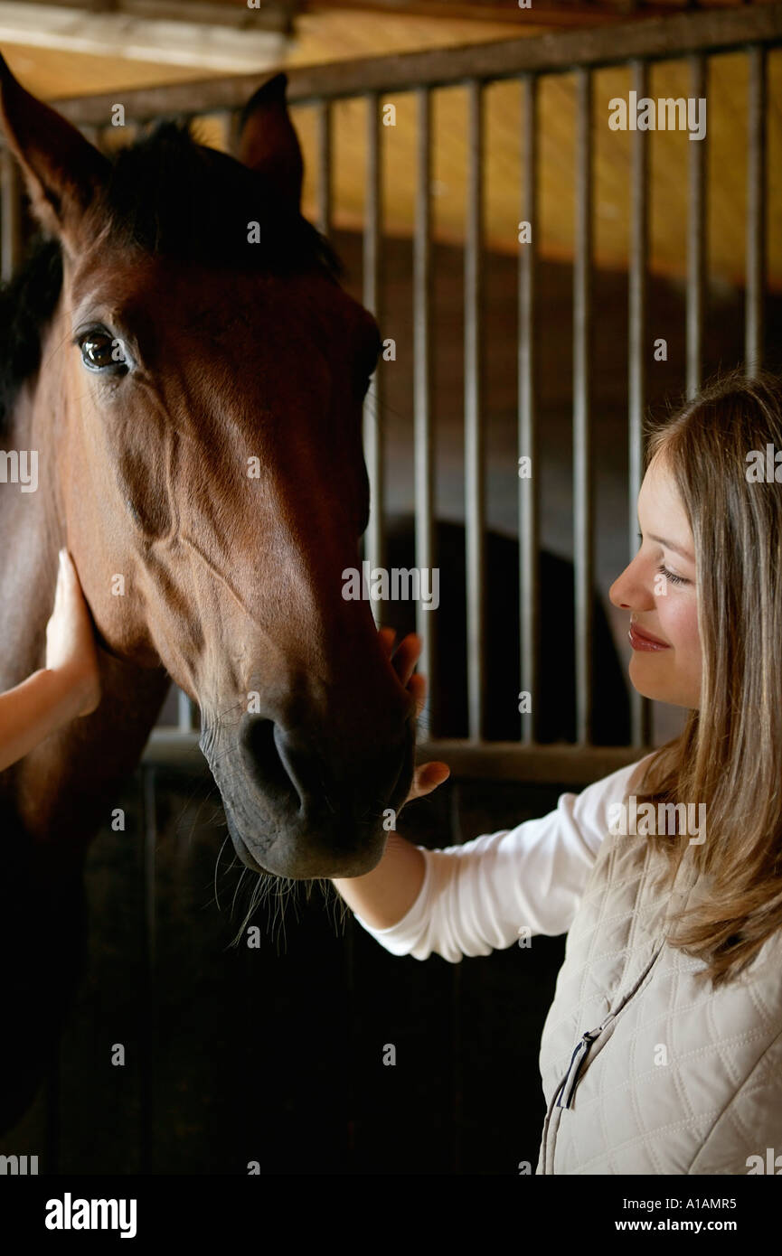 Giovane donna cavallo di accarezzare il volto Foto Stock