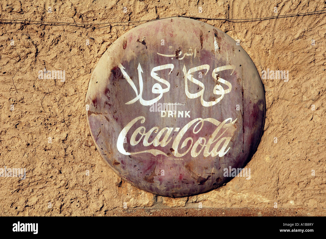 Vecchio weathered Coca Cola logo pubblicitario su una parete di fango in Egitto Foto Stock