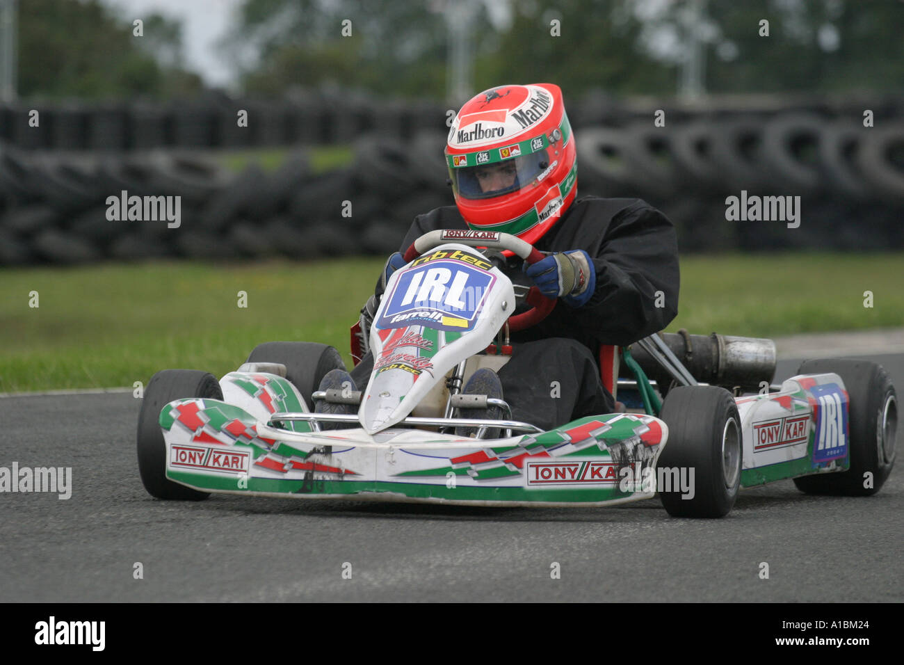 Rotax Max kart indossando replica Eddie Irvine casco ad angolo Nutts circuito motorsport nella contea di Antrim Irlanda del Nord Foto Stock
