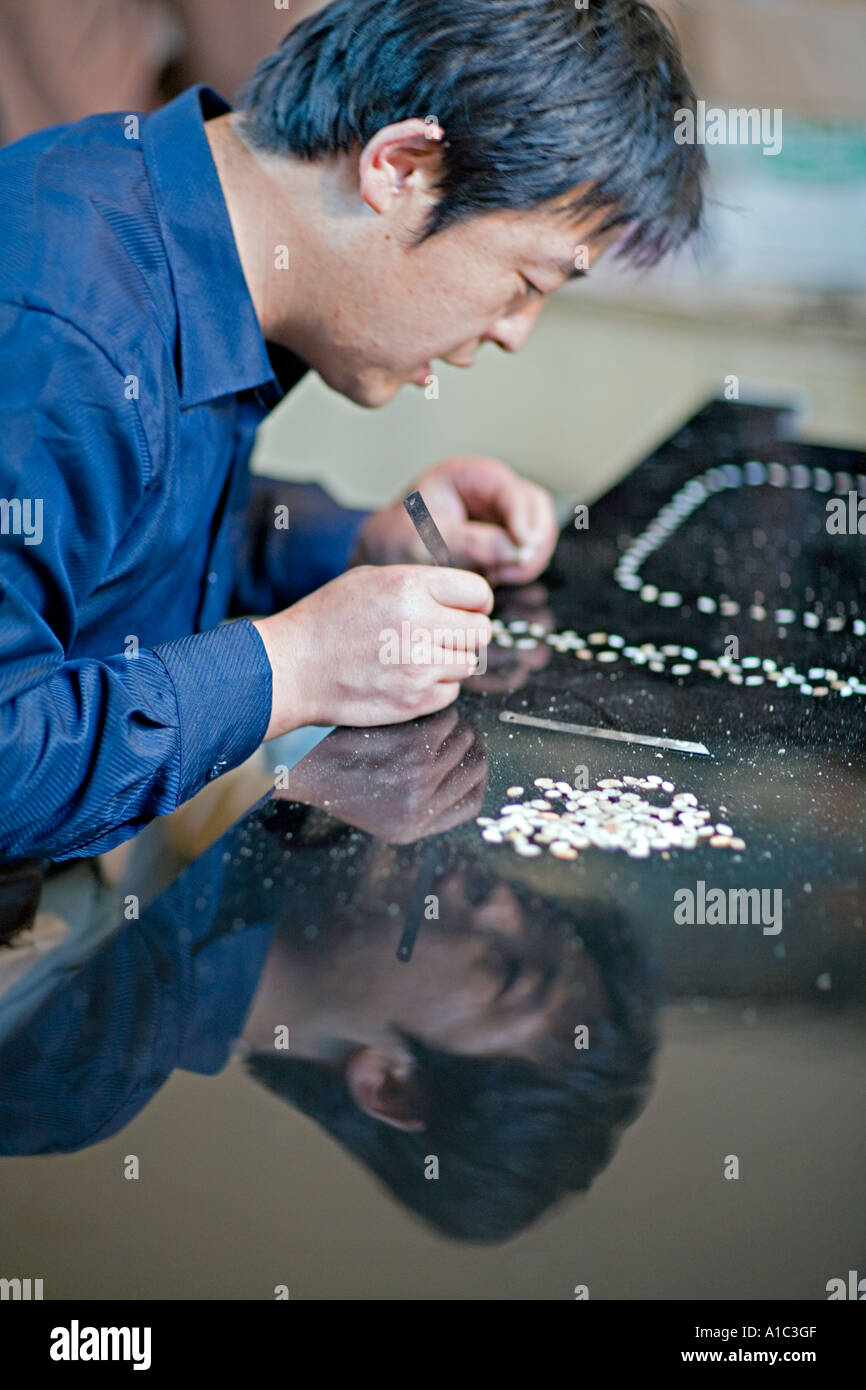 Cina Xi'an maschio artista cinese intarsio di pietre preziose in mobili  laccati in nero Foto stock - Alamy