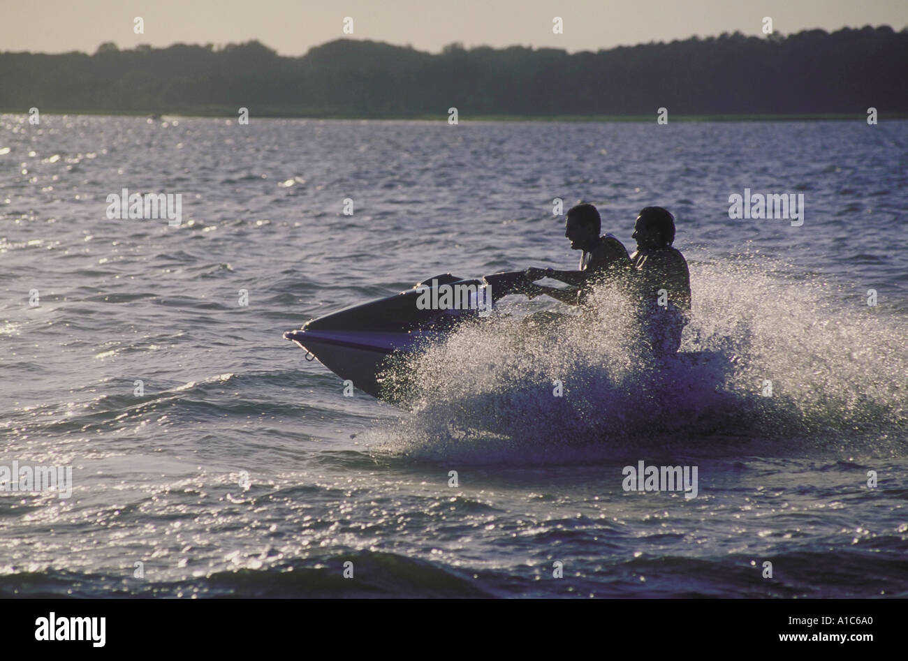 Due giovani uomini avente un eccitante corsa su un natante personale PWC noto anche come jet sci o waverunners Foto Stock