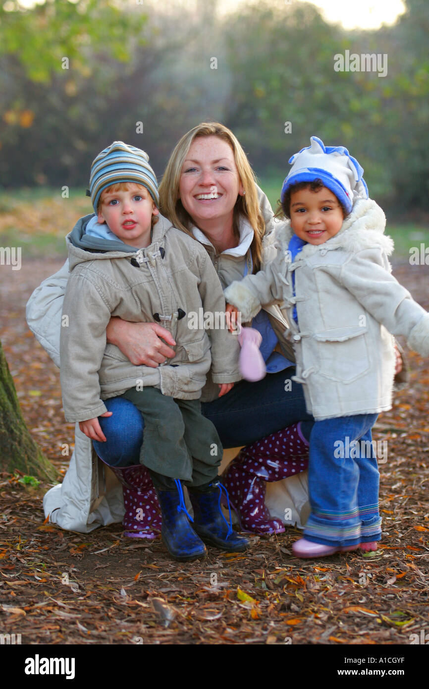 Una giovane famiglia avente una passeggiata in un parco avvolto a caldo contro il freddo Foto Stock
