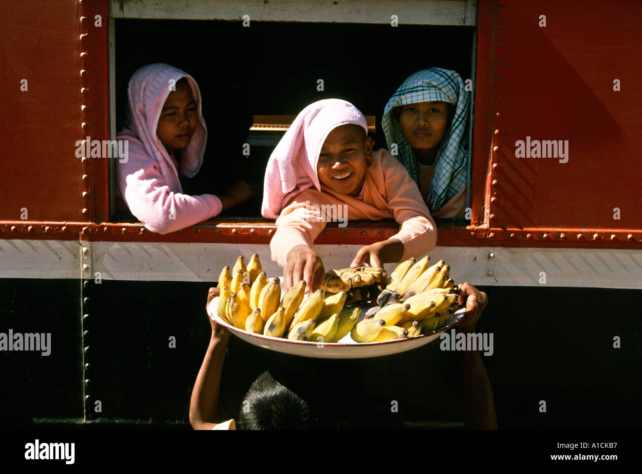 Myanmar Birmania monache di trasporto Acquisto di frutta dal treno in ambito rurale stazione ferroviaria Foto Stock