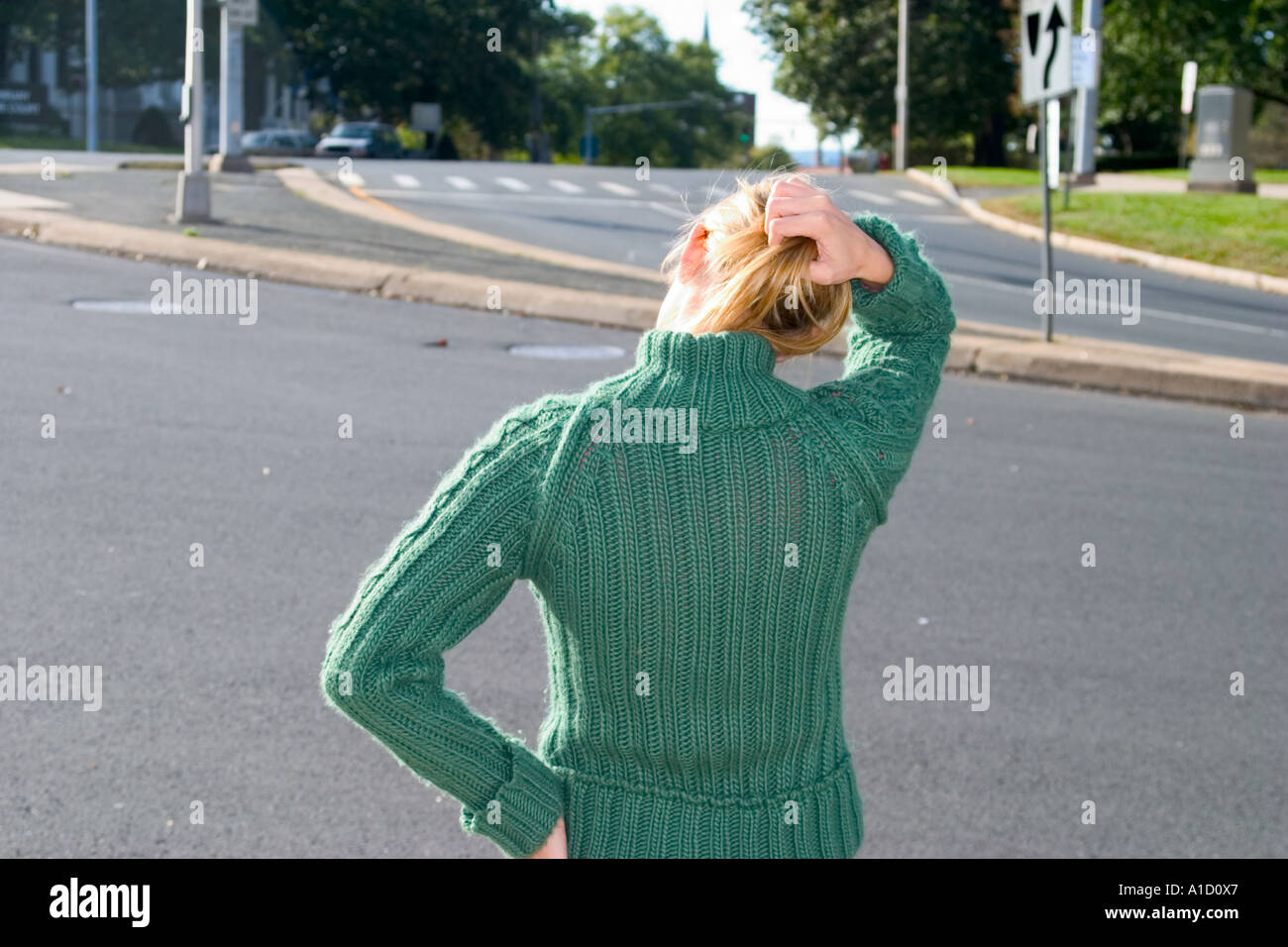 Giovane donna bionda in piedi accanto ad una strada di città modello rilasciato Foto Stock