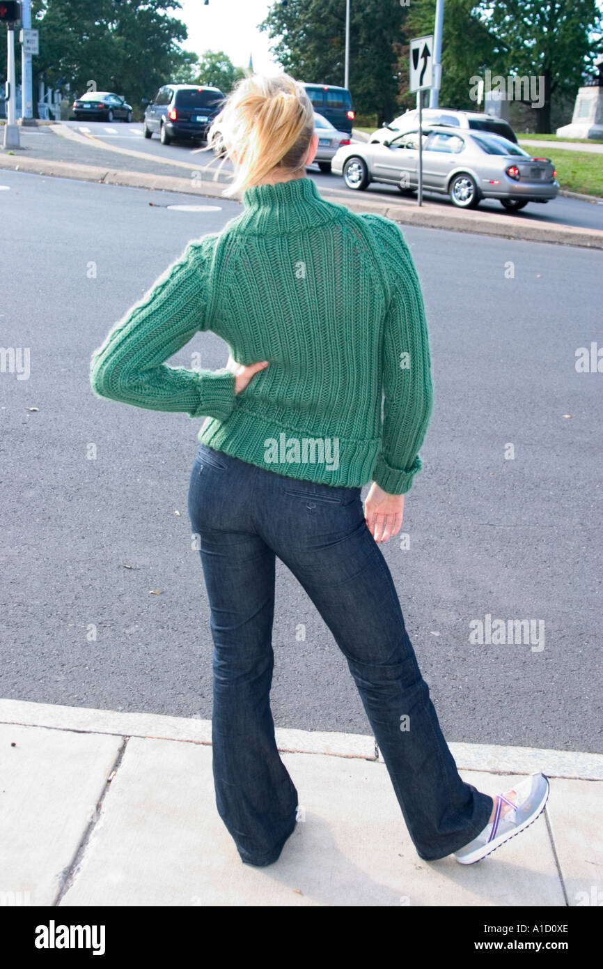 Giovane donna bionda in piedi accanto ad una strada di città modello rilasciato Foto Stock