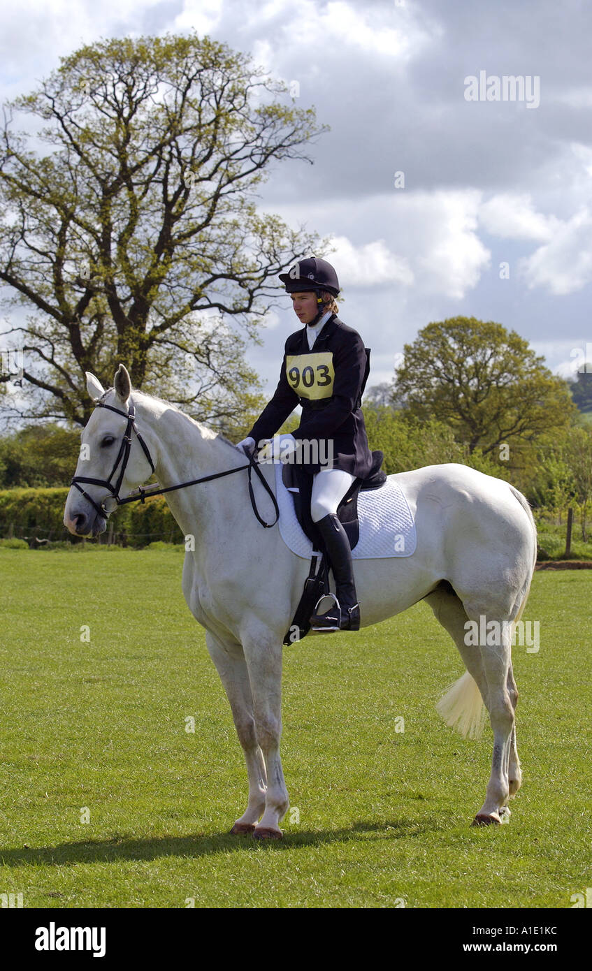 Giovane uomo su grigio mare cavallo si prepara a cavalcare dressage a eventing concorrenza Oxfordshire, Regno Unito Foto Stock