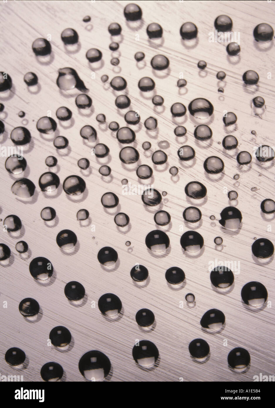 Foto ravvicinata delle gocce d'acqua sul vetro lubrificato, che mostra la tensione superficiale e le forme sferiche. Rilevante per la fisica e la scienza dei materiali Foto Stock