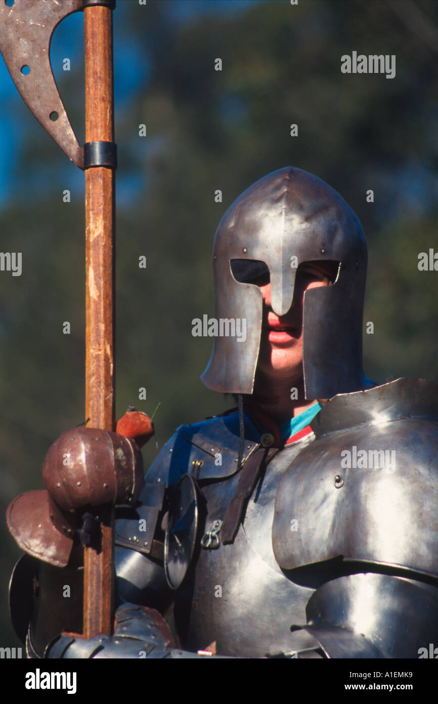 Il guerriero medievale in pieno casco e piastra metallica corazza tenendo un alto warfare gancio attrezzatura Foto Stock