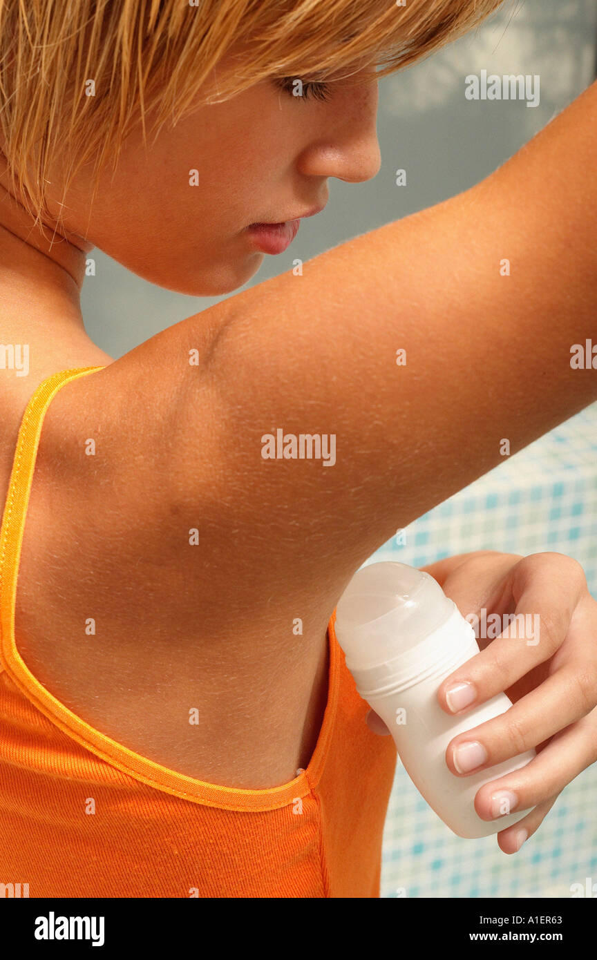Giovane donna di applicare deodoranti Foto Stock