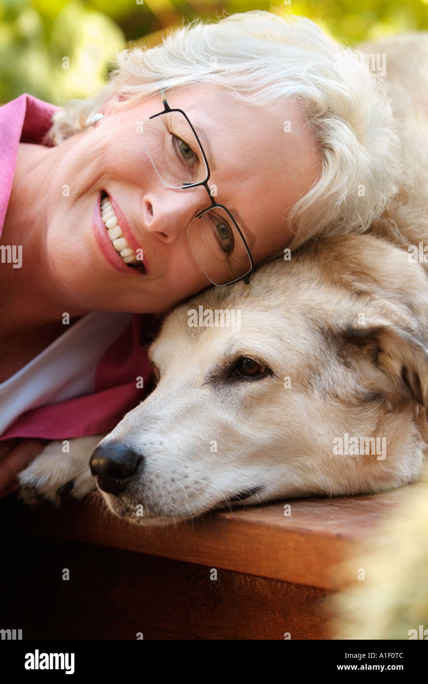 Donna in appoggio con la sua testa sulla sua testa del cane, Foto Stock