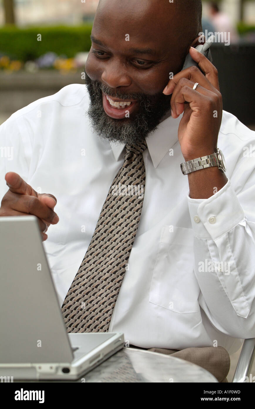 African American Uomo con laptop e parlando al cellulare Foto Stock