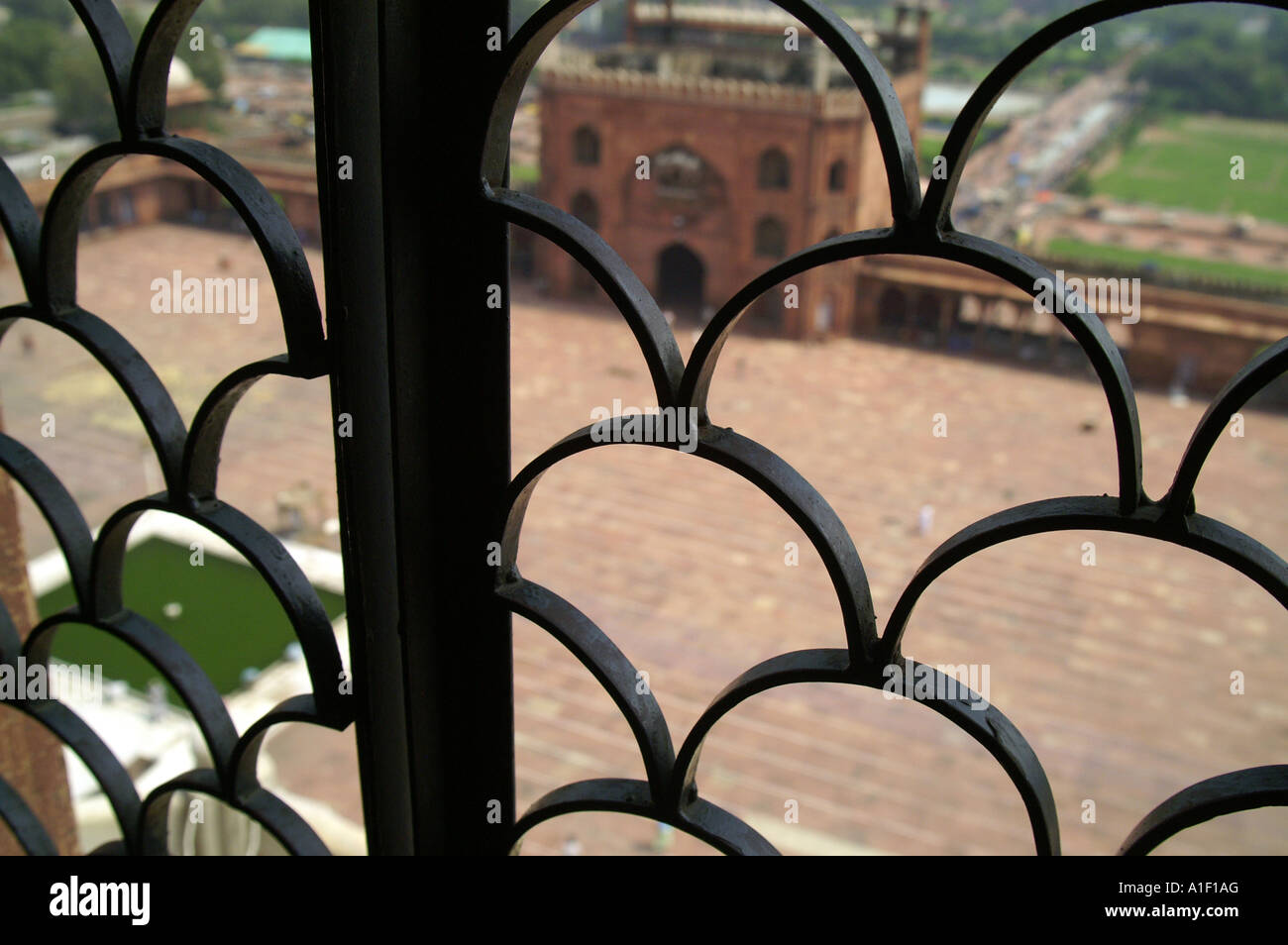 Griglia nella finestra della Jama Masjid moschea minar, vista della Moschea patio Foto Stock