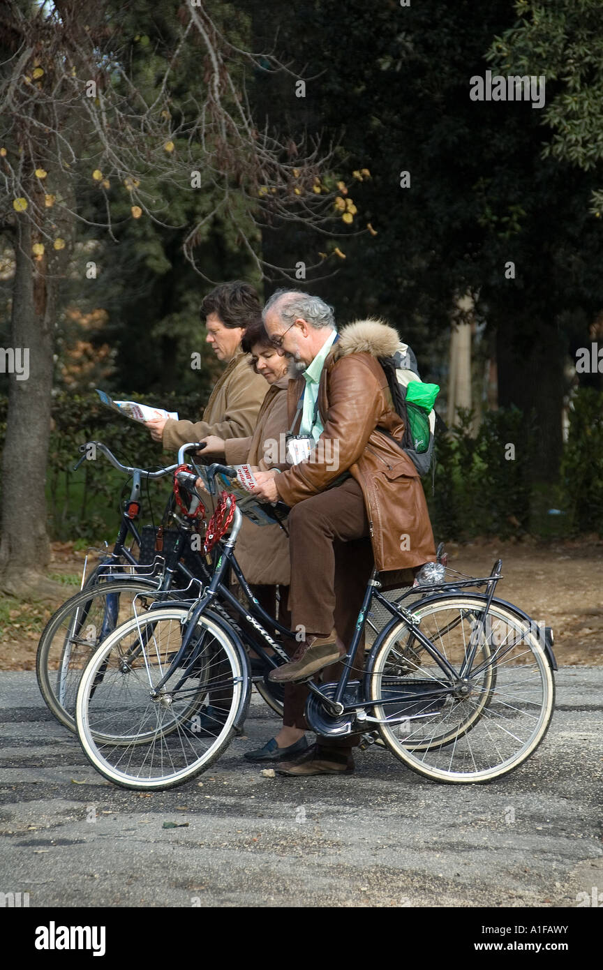 I turisti anziani esaminano le mappe mentre viaggiano in bicicletta nei giardini di Villa Borghese, Roma Italia Foto Stock