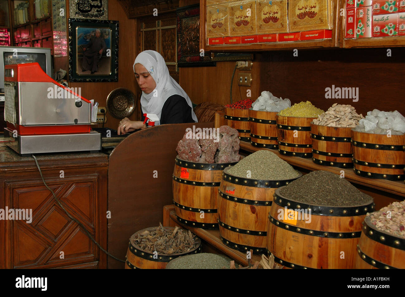 Un egiziano negoziante conteggiare denaro dietro una cassa o un registratore di cassa in Khan el-Khalili un grande souk nel centro storico del Cairo islamico Egitto Foto Stock