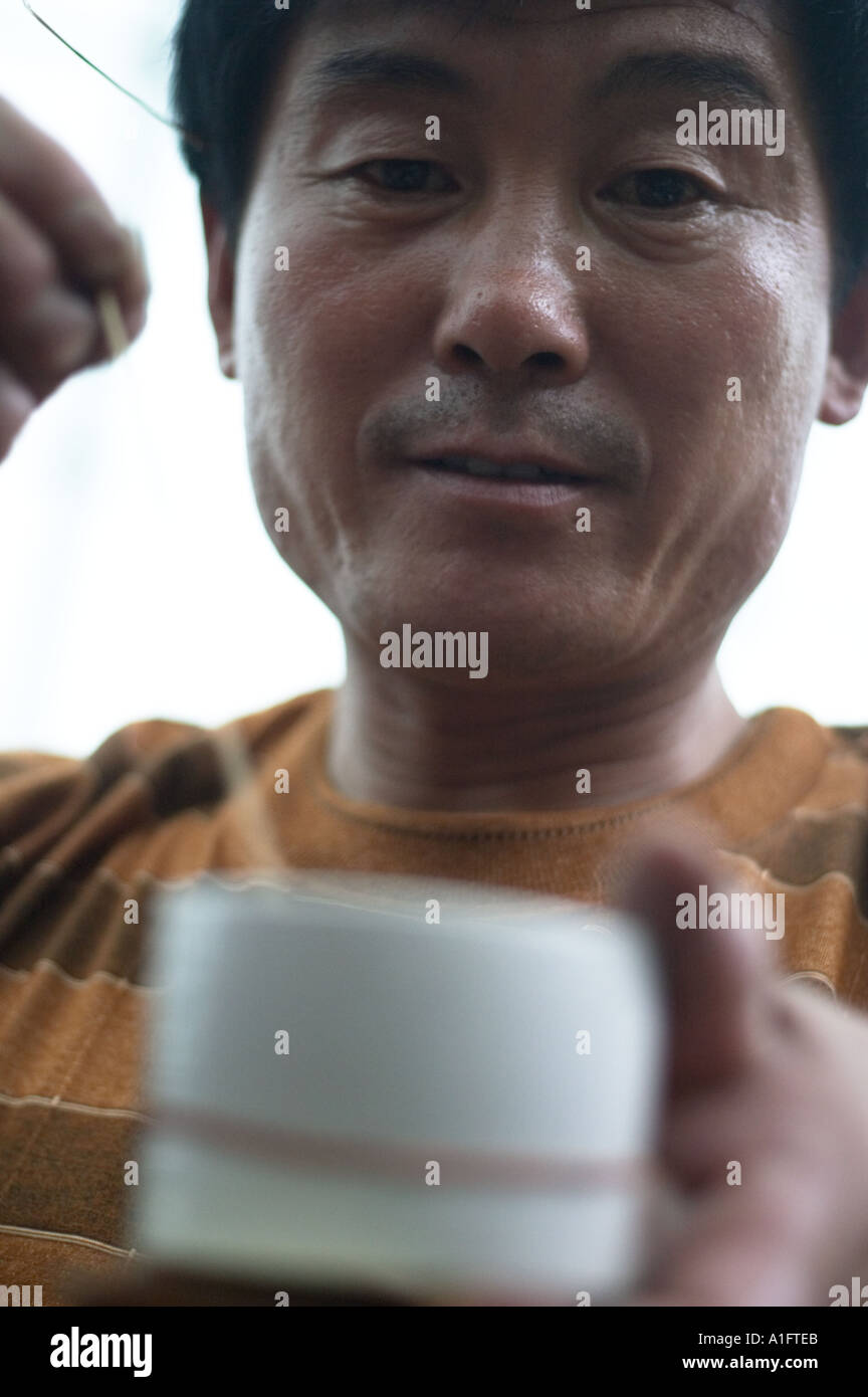 Cricket lotta popolare è un tempo di passaggio in Cina questi uomini sono la visualizzazione scegliendo Selezione di acquistare quindi le scommesse su combattimenti e guardare i grilli insetti a dongtai fiore pesci di uccelli ed insetti mercato cinese di Shanghai i grilli sono venduti in piccoli vasi e vengono agitati con un bastone per vedere quanto bene si sarebbe lotta Foto Stock