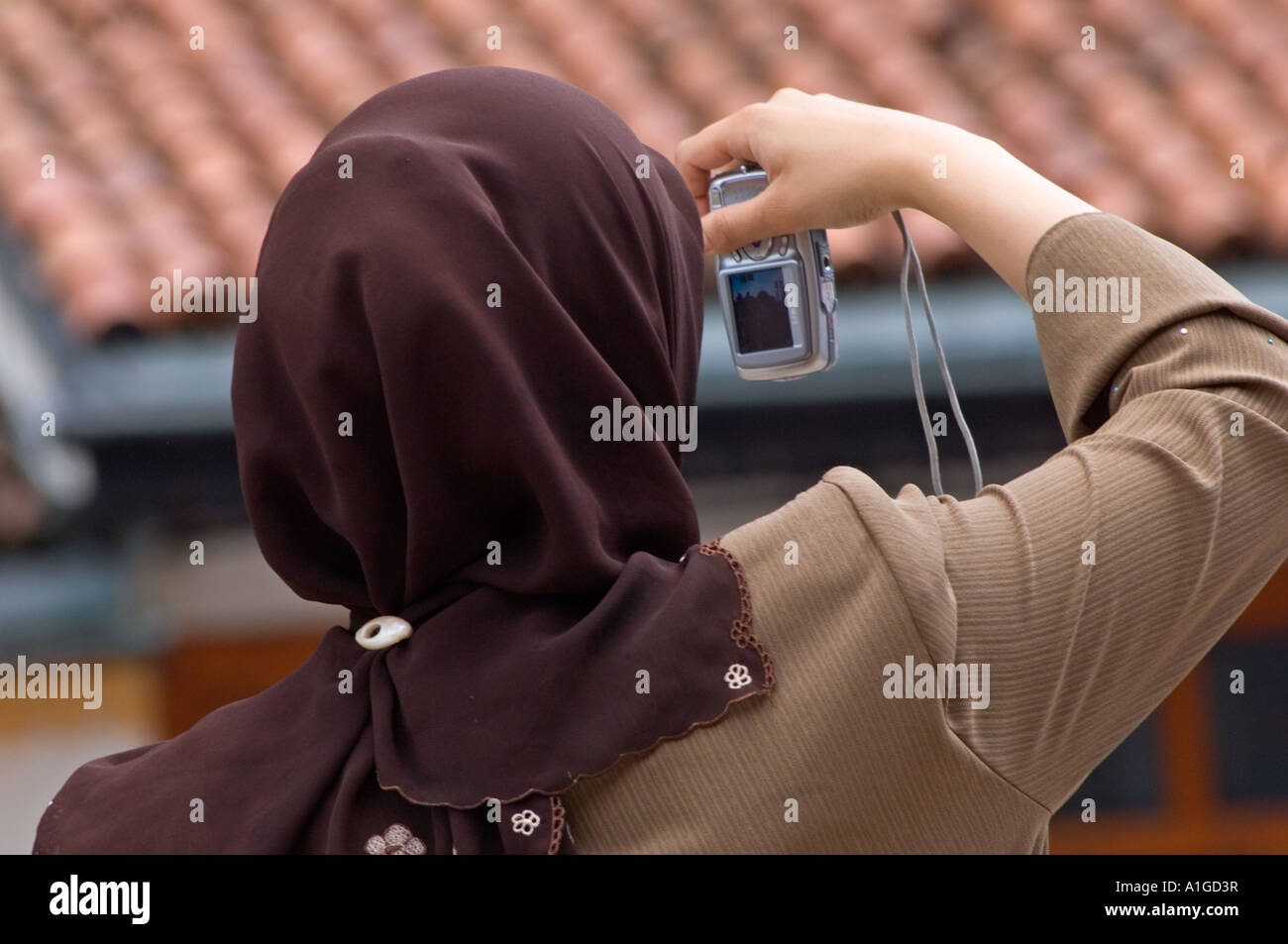 Una donna musulmana prende una foto in Bascarsija quartiere turco Sebilj Fontana e Moschea Husrevbey Sarajevo in Bosnia e Herzogov Foto Stock