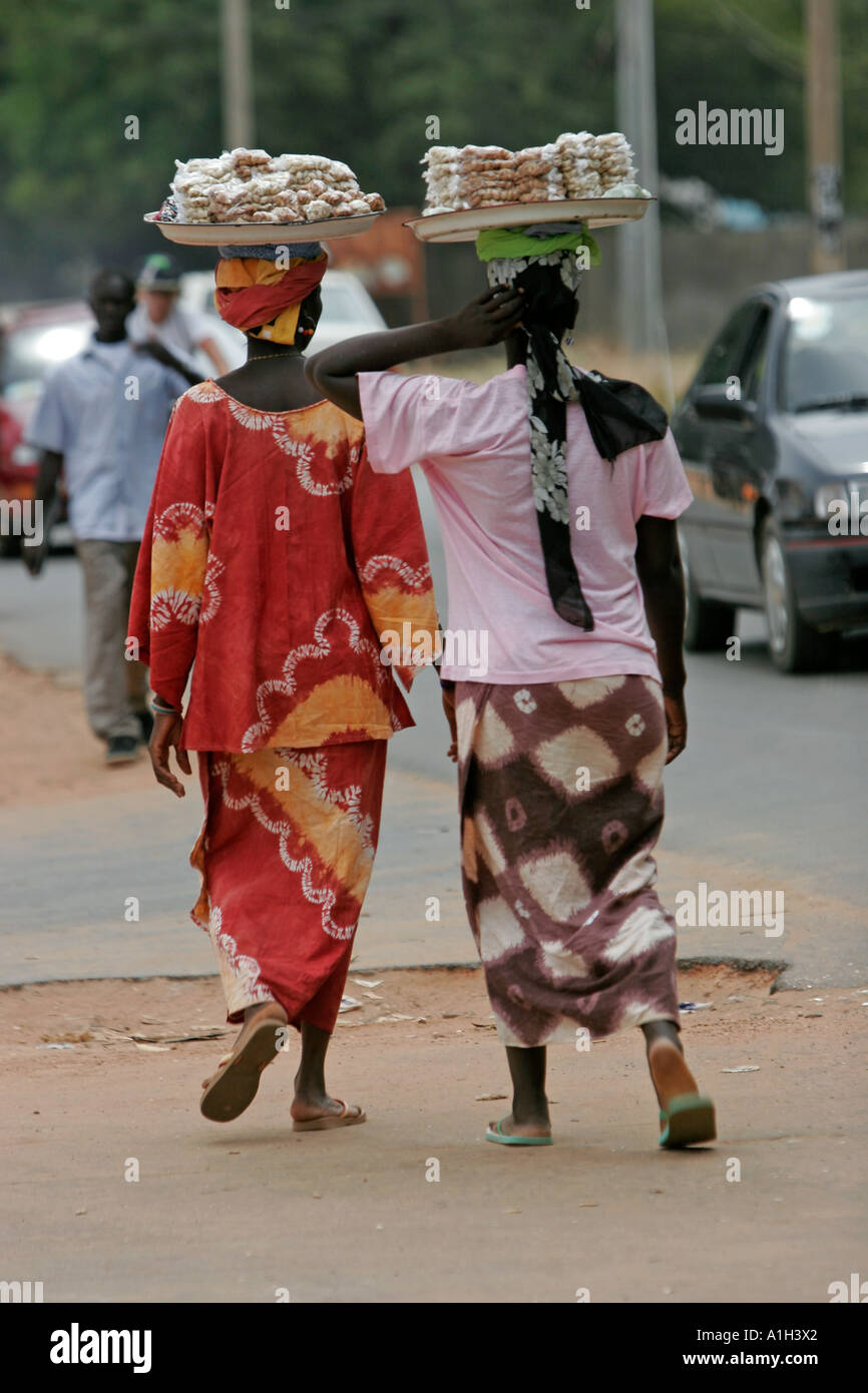 Due donne che portano vassoi di dadi su capi Bakau Gambia Foto Stock