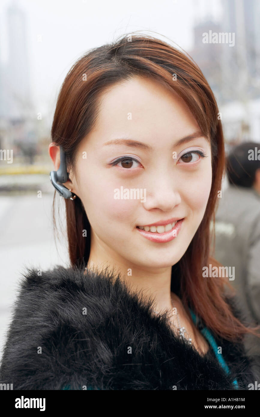 Ritratto di una giovane donna che indossa un dispositivo vivavoce Foto Stock